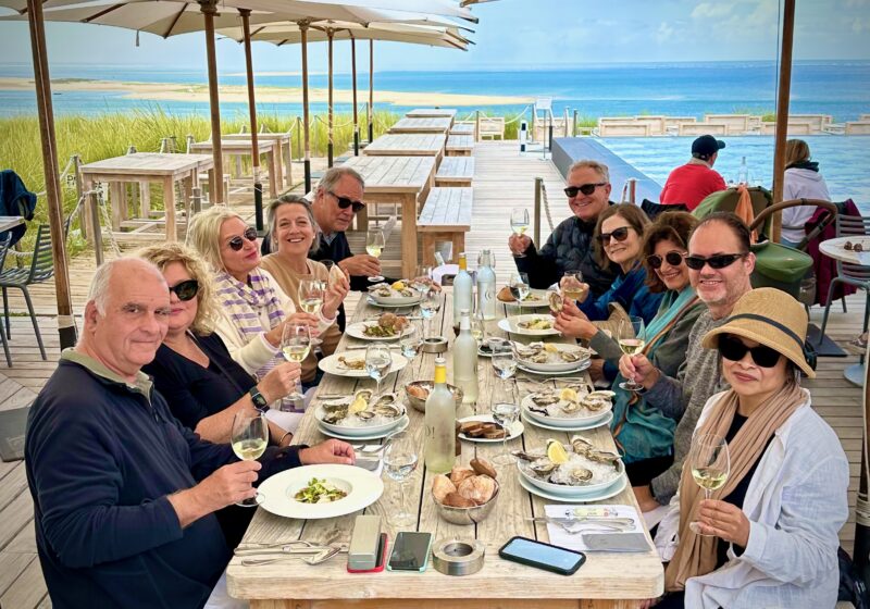 Bordeaux tour guests enjoying lunch overlooking Pyla dune and Arcachon Basin during France Off the Beaten Path Tours.